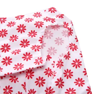 Detailed close-up of the red floral daisy pattern on white pet summer dress fabric