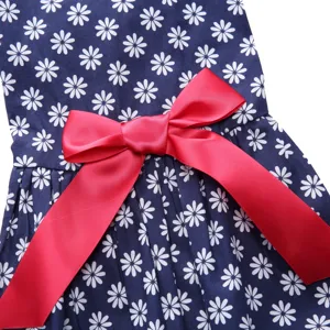 Close-up detail of a navy blue daisy print pet dress featuring a large red satin bow