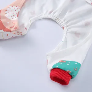 Detailaufnahme von weichem Hunde-Schlafanzug mit roten Bündchen und dem Igel-Druck