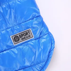 Close-up view of the warm winter pet jacket quilting texture, metallic sport wear badge detail.
