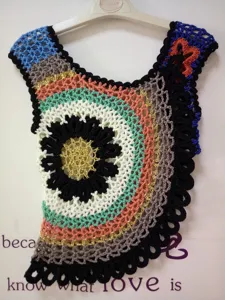 Handmade crochet colorful floral pattern sleeveless vest top detail view, bohemian style.