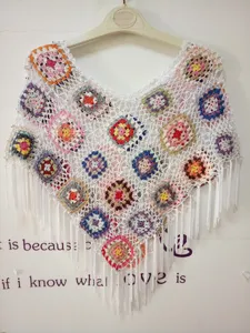 Handmade crochet poncho detail featuring colorful granny square patterns and stylish fringe.