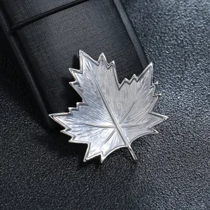 Close-up detail of silver maple leaf brooch with delicate textured metal finish