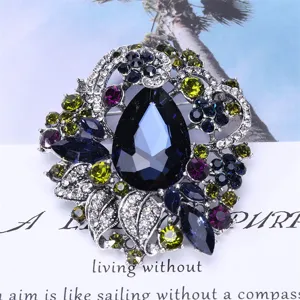 Macro detail of a Bohemian vintage crystal brooch with a large navy blue teardrop center.