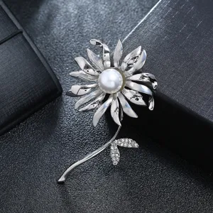 Close-up detail of an elegant silver flower brooch with white pearl and crystal leaves