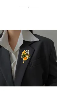 Detailed view of a vintage maple leaf enamel brooch pinned on a black blazer lapel.