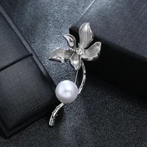 Close-up of vintage silver flower brooch with large white pearl and crystal center