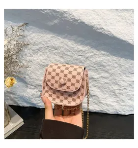 Detalle del mini bolso bandolera rosa con patrón floral vintage y cadena dorada
