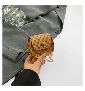 Vista detallada de un mini bolso bandolera vintage marrón con cadena dorada elegante