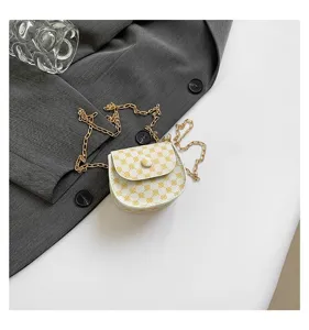 Primer plano de mini bolso bandolera blanco con patrón amarillo y cadena dorada