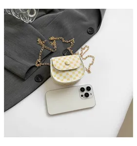 Pequeño bolso bandolera con cadena dorada junto a un móvil para ver el tamaño.