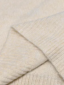 Makroansicht des cremefarbenen Strickwesten-Stoffs mit weicher Rippenstrick-Struktur