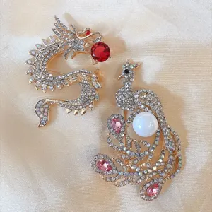 Exquisite detail of vintage crystal dragon and phoenix brooches on elegant gold satin