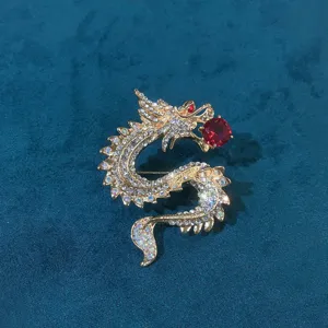 Detailed macro shot of vintage gold-plated dragon brooch with sparkling red crystals