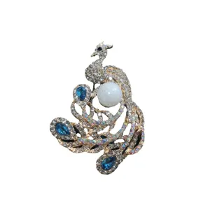 Elegant peacock brooch with sparkling rhinestones and white pearl on white background