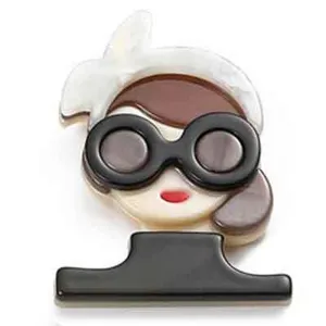 Close-up detail of an acrylic brooch featuring a girl with sunglasses and a headscarf