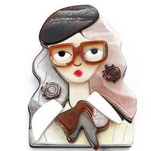 Détail d'une broche en acrylique avec design de fille à lunettes vintage