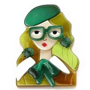 Gros plan d'une broche artistique en acrylique faite main d'une fille avec lunettes et béret