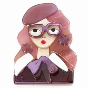 Gros plan détaillé d'une broche en acrylique représentant une fille à lunettes et béret.