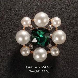 Dettaglio spilla medaglione vintage con cristallo verde e perle, dimensioni 4,0x4,1 cm.