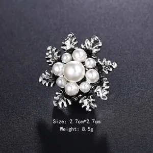Dettaglio macro di un'elegante spilla a fiocco di neve vintage in argento con perle