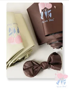 Close-up of tulip printed umbrellas in beige and brown with matching bow accessory