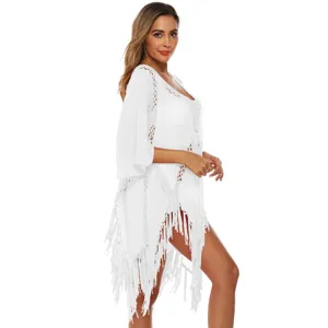 Side view of white crochet beach cover-up featuring bell sleeves and tassel fringe details