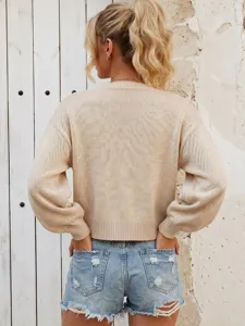 Detail view of women's beige knit cardigan back and denim shorts, casual autumn style.