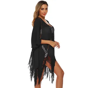 Detailed side view of black crochet beach cover-up with trumpet sleeves and fringe tassels