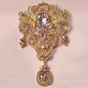 Detailansicht einer goldenen Kronenbrosche mit rosa Tropfensteinen und Strasssteinen.