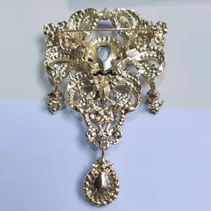 Detaillierte Rückansicht der goldenen Kronenbrosche mit Nadelverschluss und Anhängern