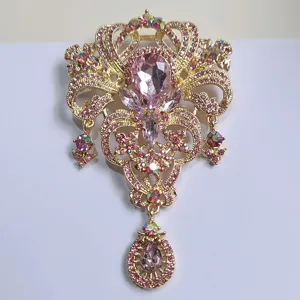 Detailansicht einer eleganten Kronenbrosche mit rosa Strasssteinen und Tropfenanhänger