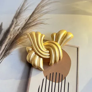 Detaillierte Nahaufnahme einer matten Goldbrosche im eleganten Vintage-Stil Design