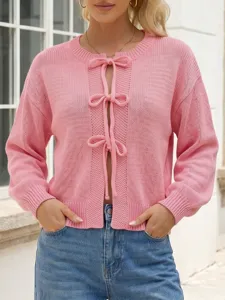 Pink knit cardigan with front bow ties and long sleeves. Elegant and comfortable style for daily wear.