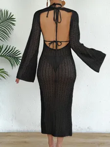 Back view of a black crochet mesh beach dress with bell sleeves and open back design.