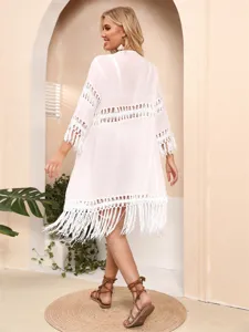 Back view of a white loose beach cardigan with fringe and hollow-out lace details.