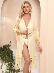 Close-up of the delicate crochet lace and flowing tassel hem on this beach cardigan