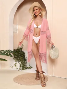 Bohemian pink tassel beach cover-up cardigan with crochet details in vacation setting