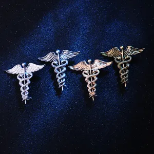 Makroansicht von vier metallischen Vintage-Merkurstab-Broschen mit Schlangendesign