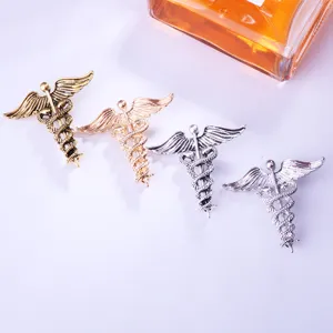Detailansicht von Retro-Caduceus-Broschen in Gold, Roségold und Silber für Arzt und Pflege