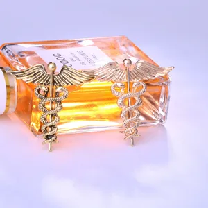 Nahaufnahme von Retro-Caduceus-Anstecknadeln mit Flügeln und Schlangen in Gold und Antik-Optik