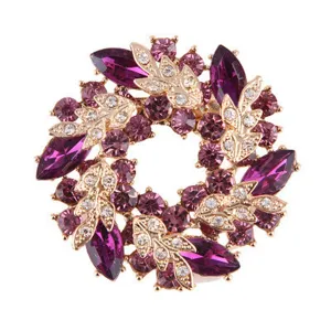 Detailansicht einer eleganten Blumenkranz-Brosche mit lila Kristallen und goldenen Blättern
