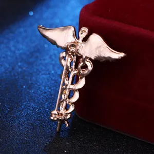 Detailansicht der Rückseite einer goldenen Caduceus-Brosche mit Engelsflügeln und Nadel