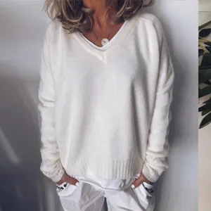 Detail shot of a cozy white V-neck knitted sweater, loose pullover fit for autumn and winter.