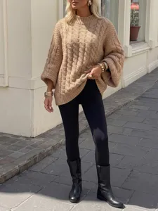 Detailaufnahme eines kuscheligen Grobstrick-Pullovers, im Freien stilvoll getragen.