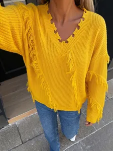 Detailed view of bright yellow V-neck knit sweater with asymmetric fringe and relaxed fit.