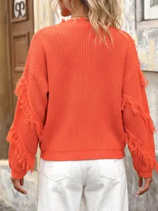 Detail view of women orange fringe knit sweater, stylish loose pullover with distressed collar.