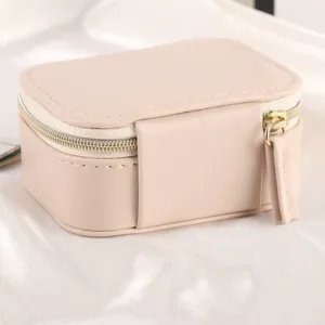 Portable mini jewelry storage box in nude peach faux leather with a secure zipper closure