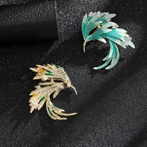 Detail view of vintage phoenix wing brooches showing front enamel and back clasp