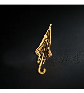 Back view detail of creative gold umbrella brooch showing safe pin closure mechanism